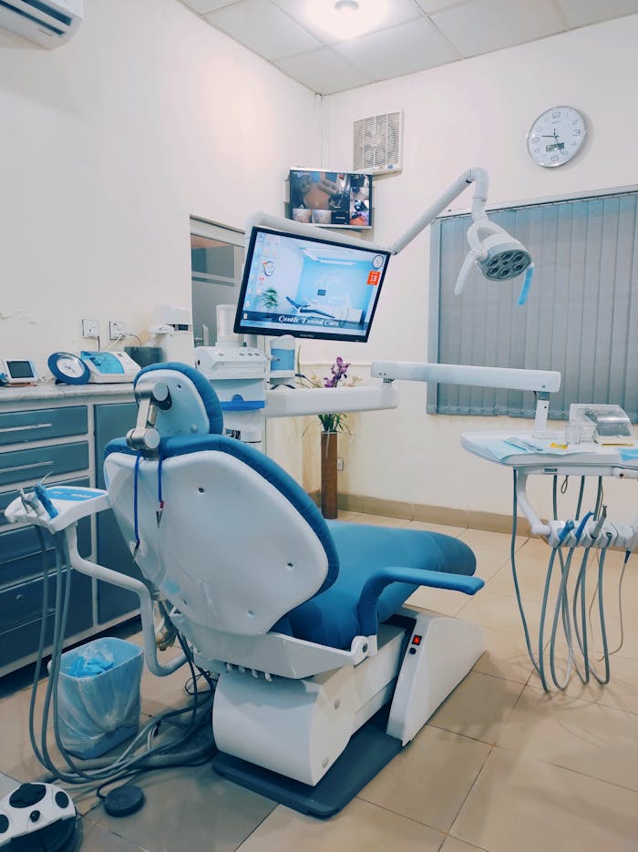 Home A fully equipped dental clinic room showcasing a dental chair and tools for patient care.