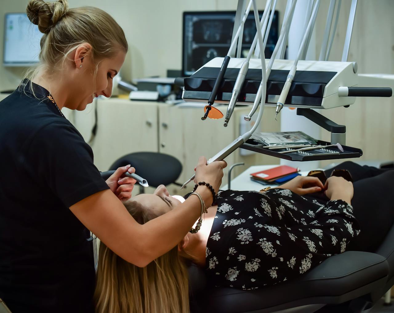 Home Dental professional conducting examination with advanced equipment in a modern clinic, ensuring patient comfort.